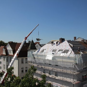 crane moving roofing tiles